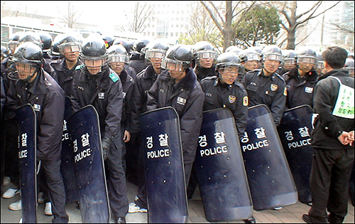 경찰이 방패날을 세운 채 공격 준비를 하고 있다. 